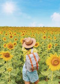 Happy young asianwoman walking in a sunflower field