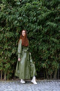 Portrait of woman standing against plants