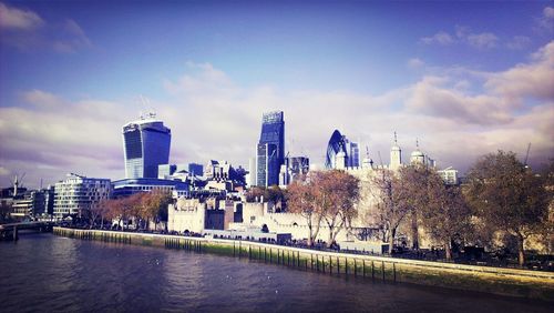 Buildings in city against cloudy sky