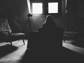 Silhouette woman sitting at home