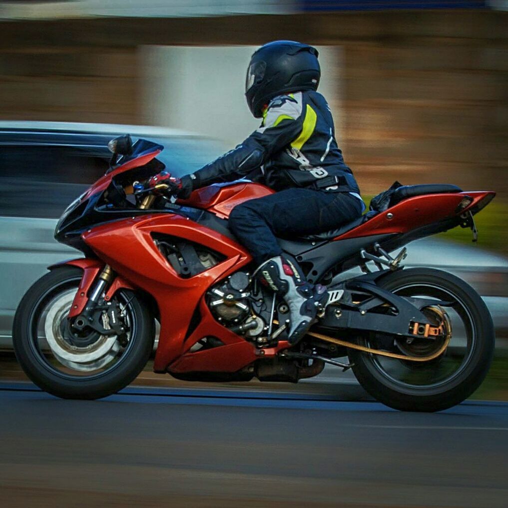 MAN RIDING MOTORCYCLE ON BICYCLE