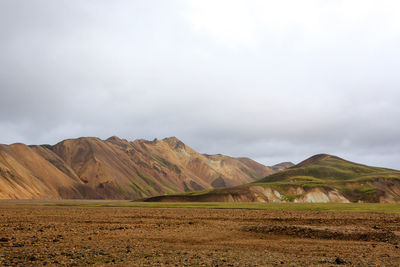 Scenic view of field and mountains against sky