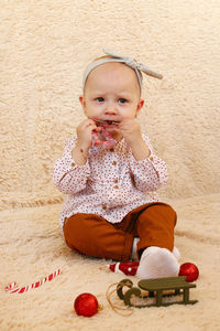 Portrait of cute girl sitting on sofa at home