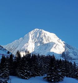 Snow covered mountains against clear blue sky
