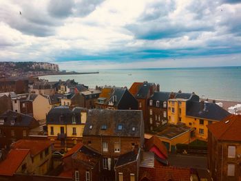 High angle view of townscape by sea against sky