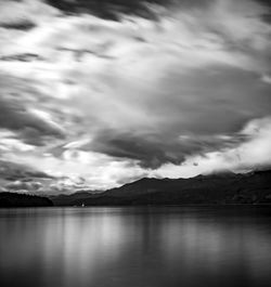 Scenic view of lake by mountains against sky