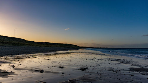 Scenic view of beach against sky during sunset