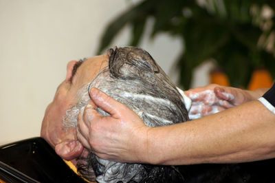 Close-up of man getting hair washed at salon