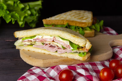 Triangular sandwiches with toast, lettuce and vegetables on a dark background. healthy and delicious