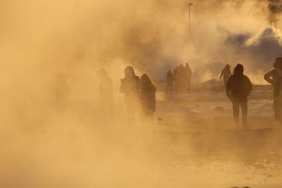 People standing on shore against sky