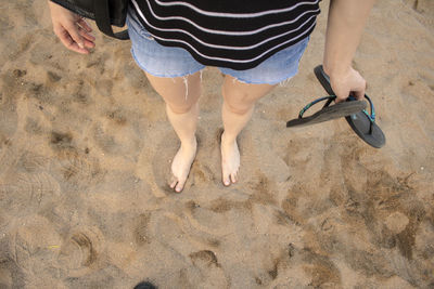 Low section of woman standing on beach