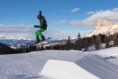 Man skiing on snowcapped mountain against sky