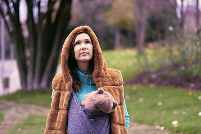 Woman wearing costume looking up while standing outdoors