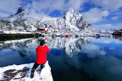 Rear view of person on snowcapped mountain against sky