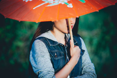 Midsection of woman holding umbrella