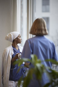 Female doctors standing and talking at hospital corridor