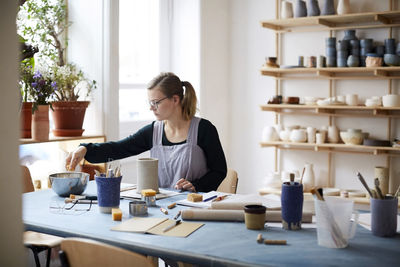 Young woman learning pottery in art class