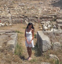 Full length of woman standing against wall