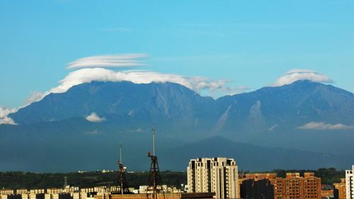 View of cityscape against cloudy sky