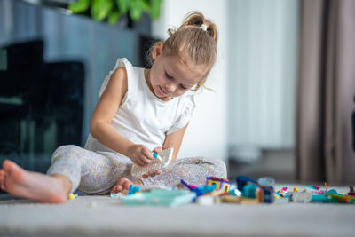 Side view of girl playing with toys on table