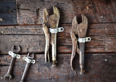 Close-up of hand tools hanging on wooden wall