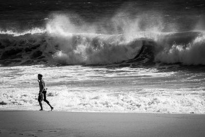 Man surfing on sea shore