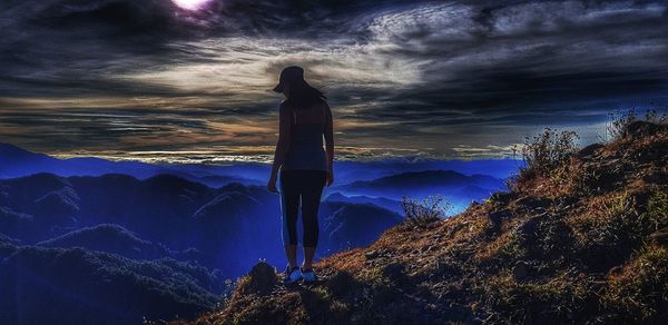 Silhouette person by tree against sky during sunset