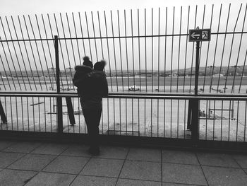 Rear view of man standing by railing