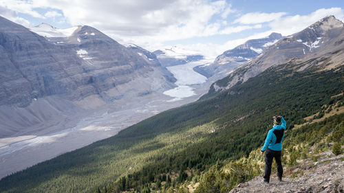 Male hiker enjoying the view on untouched alpine valley with glacier on its end, jasper, canada