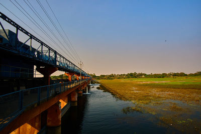 Bridge over river against sky during sunset