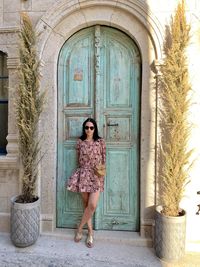 Full length of woman standing against closed door