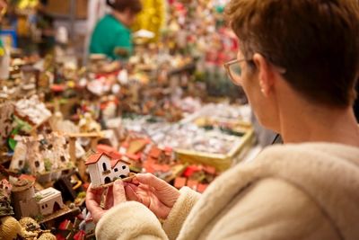 Woman buying decorations at market during night