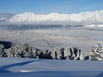 Scenic view of snow covered mountains against sky