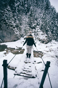 Man standing on snow covered tree