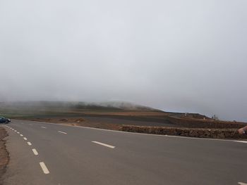 Road by landscape against sky