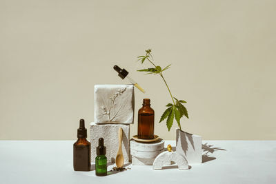 Cbd oil, cannabis setting in different bottles and marijuana leaf, cannabis in  still life on podium