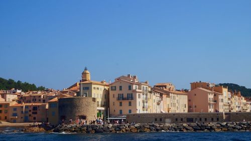 Buildings in city against clear blue sky