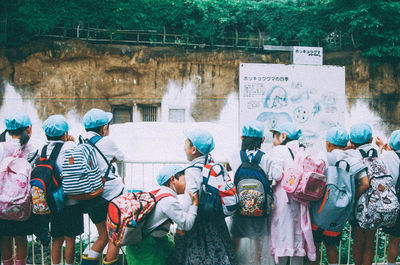 School children standing by fountain in park