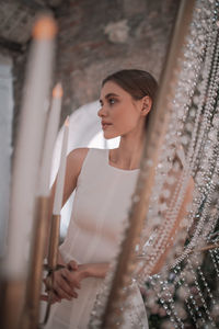 Young woman looking away while standing on store