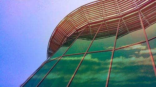 Low angle view of modern building against blue sky