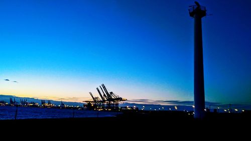 Illuminated commercial dock against clear blue sky