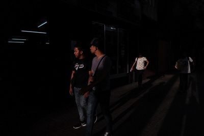 People walking on illuminated stage at night