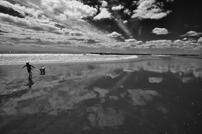 People on beach against sky