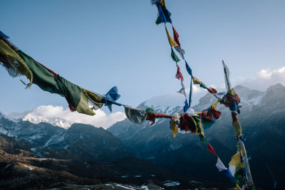 Low angle view of flags on mountain against sky