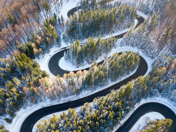 Winding road through the forest, from high mountain pass, in winter time