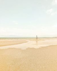 Woman standing on beach against sky