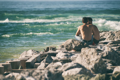 Rear view of man relaxing at beach