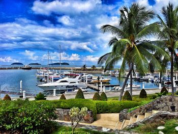 Boats in sea against cloudy sky