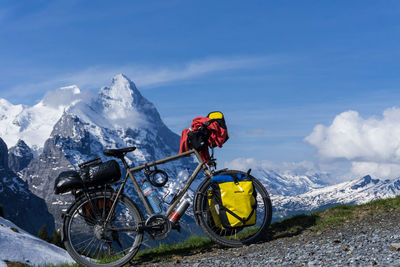 Bicycles on snowcapped mountain against sky