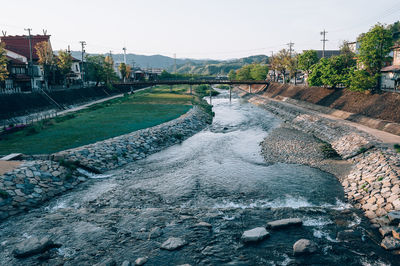 Scenic view of river against sky in city